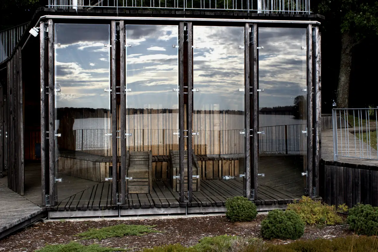 Glass house reflected in a lake at dusk