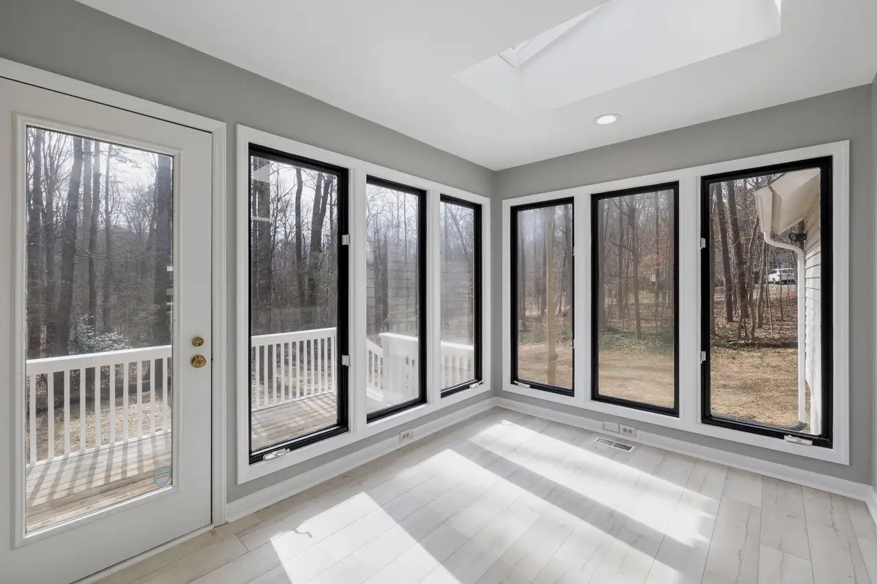 Sunroom with black-framed casements and a black French door